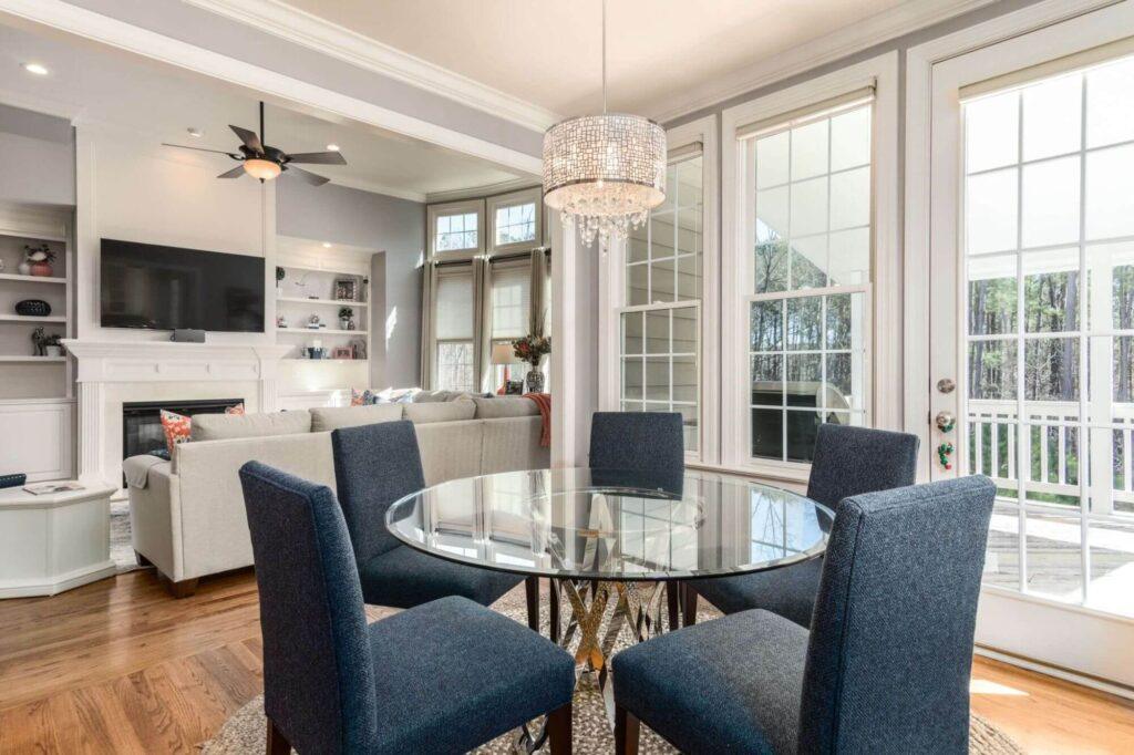 Salle à manger moderne avec table en verre et vue sur le salon.