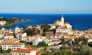 Vue de Cadaqués avec maisons blanches et église près de la mer.