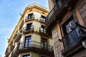 Façades de bâtiments avec balcons en fer forgé sous un ciel bleu.