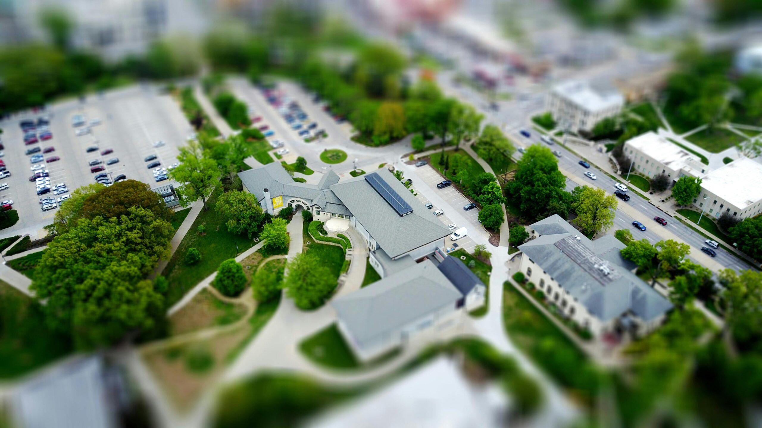 Vue aérienne d'un quartier urbain avec bâtiments, routes et espaces verts.