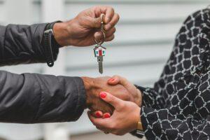pexels rdne Deux personnes se serrant la main avec une clé de maison.