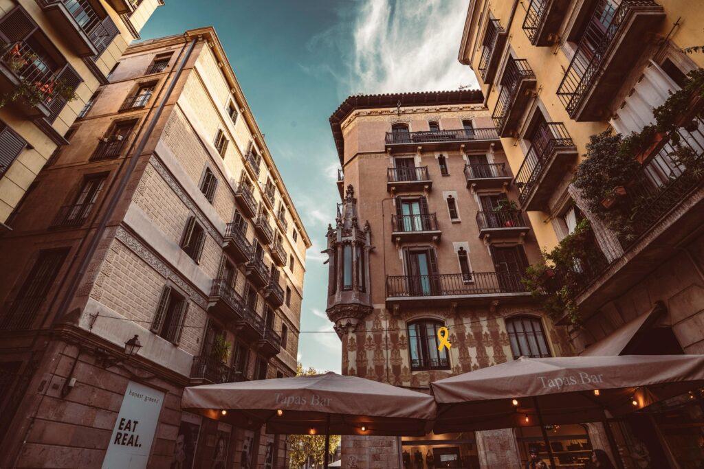 Façades de bâtiments anciens avec un bar à tapas en premier plan.