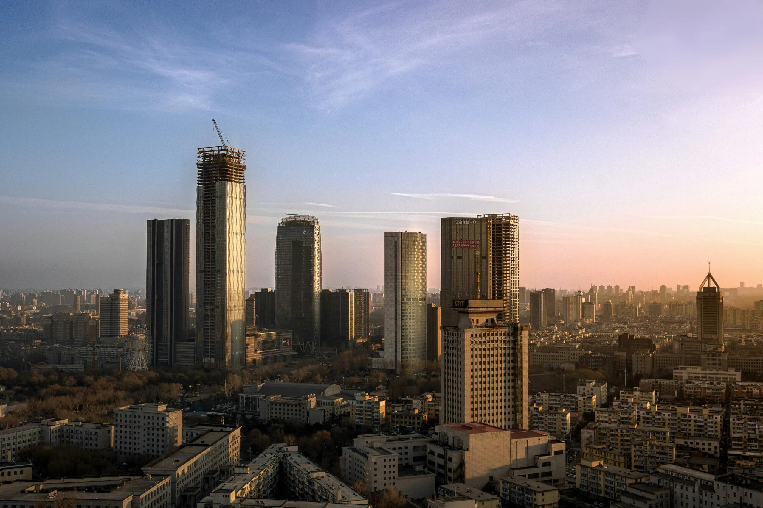 Vue aérienne d'une ville avec gratte-ciel au coucher du soleil.