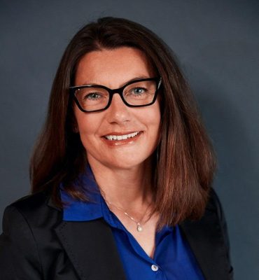 Karine martin Je ne sais pas qui est sur l'image. Texte alternatif suggéré : "Femme souriante avec lunettes et chemise bleue."
